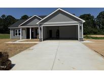 New home exterior showing large garage door and freshly poured driveway at 107 Tee Dr, Selma, NC 27576