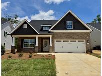 Charming brick home with a two-car garage, covered porch, and beautifully landscaped front yard under a blue sky at 1075 Fairhaven Dr # 51, Mebane, NC 27302