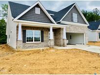 New construction home with brick facade, shake shingle accents, and attached two-car garage at 1075 Fairhaven Dr # 51, Mebane, NC 27302