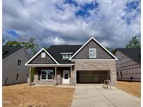 Charming single-Gathering home with brick and gray siding, two-car garage, and welcoming curb appeal at 1075 Fairhaven Dr # 51, Mebane, NC 27302
