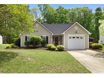 Charming single-story home featuring a well-maintained lawn, neat landscaping, and an attached one car garage at 108 Braxberry Way, Holly Springs, NC 27540