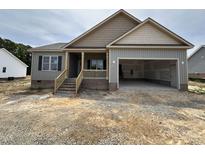 Charming single-Gathering home with a covered porch, attached garage and gray wood siding at 152 Royal Ave, Selma, NC 27576