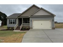 Charming single-Gathering home features a gray exterior, a two-car garage, and a well-manicured lawn at 152 Royal Ave, Selma, NC 27576