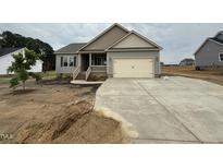 Charming single-story home with neutral siding, attached garage, and newly poured concrete driveway at 152 Royal Ave, Selma, NC 27576