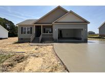 Charming single-Gathering home featuring an attached garage and a well-manicured, unfinished front yard at 152 Royal Ave, Selma, NC 27576