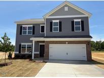 Charming two-story home with gray siding, black shutters, brick accents, and a two-car garage at 164 E Victory View. Ter, Smithfield, NC 27577