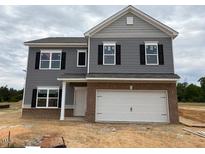 Charming two-story home with gray siding, brick accents, and a two-car garage at 164 E Victory View. Ter, Smithfield, NC 27577
