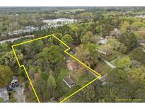 Aerial view of a large lot surrounded by trees, featuring a home and an additional building within property lines at 1823 E Geer St, Durham, NC 27704