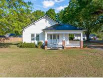 Charming white home with a covered front porch and mature landscaping at 206 Mansfield Dr, Broadway, NC 27505