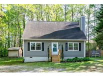 Charming home featuring gray siding, black shutters, and a wooden staircase leading to the front door at 2700 Ross Rd, Durham, NC 27703