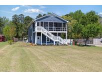 Charming two-story home with a screened-in porch and well-maintained lawn at 283 Raynor Rd, Spring Lake, NC 28390