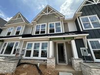 New two-story townhome with gray siding, white trim, a black roof, and stone accents on the columns at 3020 White Rail Dr, Fuquay Varina, NC 27526