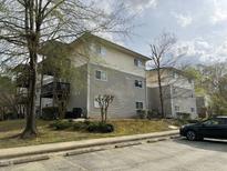 Multi-Gathering building showcasing well-maintained siding, balconies, and a parking area, set amongst mature trees and landscaping at 303 Smith Level Rd # E32, Chapel Hill, NC 27516