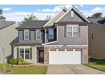 Charming two-story home with gray siding, stone accents, a two-car garage, and a well-maintained lawn at 5417 Razan St, Raleigh, NC 27616