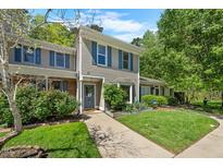 Charming townhome with well-maintained landscaping, blue shutters, and a welcoming entrance at 65 Forest Oaks Dr, Durham, NC 27705
