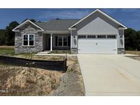 Charming single-Gathering home with stone accents and a two-car garage at 69 Tee Dr, Selma, NC 27576