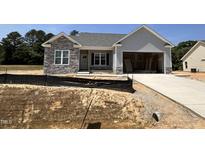 Charming single-story home featuring a stone facade, attached garage, and gray siding at 69 Tee Dr, Selma, NC 27576