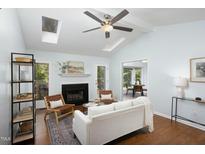 Bright living room with skylights, fireplace, and open floor plan to the dining room at 901 Clifford Dr, Durham, NC 27704