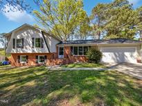 Charming brick home with two-car garage and a well-maintained front yard at 901 Forge Rd, Durham, NC 27713
