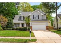 Charming two-story home with gray siding, black shutters, well-manicured lawn and mature trees at 1012 Trail Stream Way, Knightdale, NC 27545
