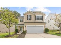 Charming two-story home with light tan siding, neat landscaping, and a two-car garage at 104 Rosebud Ln, Durham, NC 27704