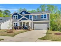 Two-story home featuring mixed siding, a two-car garage, and a meticulously landscaped front yard at 105 Scoville Rd, Garner, NC 27529