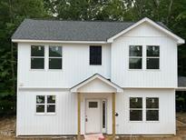 New two-story home with white vertical siding, gray roof, and symmetrical window arrangement at 12 Gates St, Roxboro, NC 27573