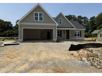 New construction home featuring an attached two car garage and lovely, light green exterior paint at 125 Tee Dr, Selma, NC 27576