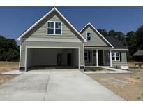 Two-story home featuring a two-car garage, shake siding and craftsman-style architectural details at 125 Tee Dr, Selma, NC 27576