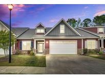Charming exterior of home with two-car garage, stone accents and manicured lawn at 153 Telluride Trl, Garner, NC 27529