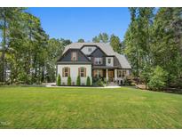 Stunning two-story home boasts a well-manicured lawn, mature trees, and inviting curb appeal at 188 E Antebellum Dr, Pittsboro, NC 27312