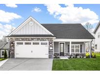Charming home featuring a stone facade, two-car garage, well-manicured lawn, and inviting front porch at 201 Benton Dr, Oxford, NC 27565