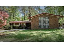 Charming brick home featuring mature landscaping and a classic mid-century modern design at 206 Rochelle Dr, Knightdale, NC 27545