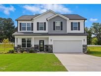 Beautiful two-story home featuring stone accents, a two-car garage, and a manicured front lawn at 21 Green Links Dr, Cameron, NC 28326