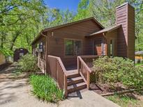 Charming home featuring a cozy front porch and a rustic exterior nestled in a lush, wooded setting at 2419 George Anderson Dr, Hillsborough, NC 27278