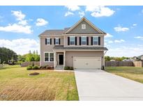 Charming two-story home features a two-car garage, well-maintained lawn, and inviting curb appeal at 275 Sunrise Ridge Dr, Willow Springs, NC 27592