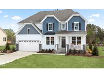 Charming two-story home featuring a mix of blue and white siding and a well-manicured lawn at 315 Adams Pointe Ct, Angier, NC 27501