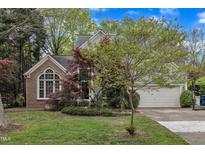 Charming home with a two-car garage, beautiful landscaping, and a mix of brick and siding at 4 Taulton Ct, Durham, NC 27705