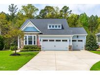 Charming home featuring a three-car garage, stone accents, and a well-manicured lawn at 408 Price Lake Way, Fuquay Varina, NC 27526
