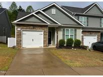 Charming townhome with stone accents, a two-car garage and inviting curb appeal at 48 Cullen Ct, Clayton, NC 27520
