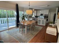 Bright dining area featuring hardwood floors, modern lighting and access to outdoor deck at 510 Braden Dr, Durham, NC 27713