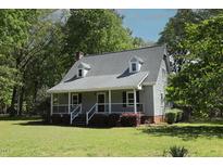 Charming home with a covered porch, black shutters, and well-manicured front yard at 5200 Lorbacher Rd, Apex, NC 27539