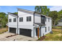 Modern two-story home featuring a white and black color scheme and an attached garage with black door at 836 Day Ave, Burlington, NC 27217