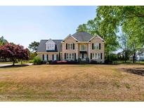 Charming two-story brick home with black shutters and a well-manicured lawn at 8409 Muirfield Dr, Fuquay Varina, NC 27526