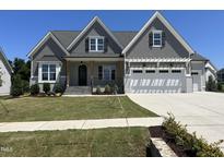 Charming gray two-story home featuring a landscaped front yard, covered porch, and two-car garage at 921 Lily Claire Ln, Fuquay Varina, NC 27526