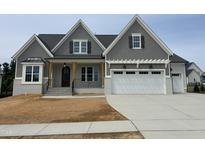 Beautiful craftsman home featuring a gray shingle exterior, white painted brick and a two-car garage at 921 Lily Claire Ln, Fuquay Varina, NC 27526
