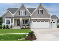 Charming two-story home with a beautifully landscaped front yard and a three-car garage at 921 Lily Claire Ln, Fuquay Varina, NC 27526
