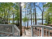 Beautiful lake view from the backyard deck with stairs leading down to the water at 104 Chuckwagon Dr, Louisburg, NC 27549