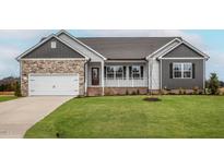 Charming single-story home featuring a stone facade, a well-manicured lawn, and an attached two-car garage at 11470 International Dr, Middlesex, NC 27557