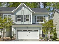 Charming townhouse with a two-car garage and light blue siding offers modern curb appeal at 1614 Brussels Drive Dr, Apex, NC 27502